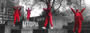 Four dancers in red jumpsuits in an urban space